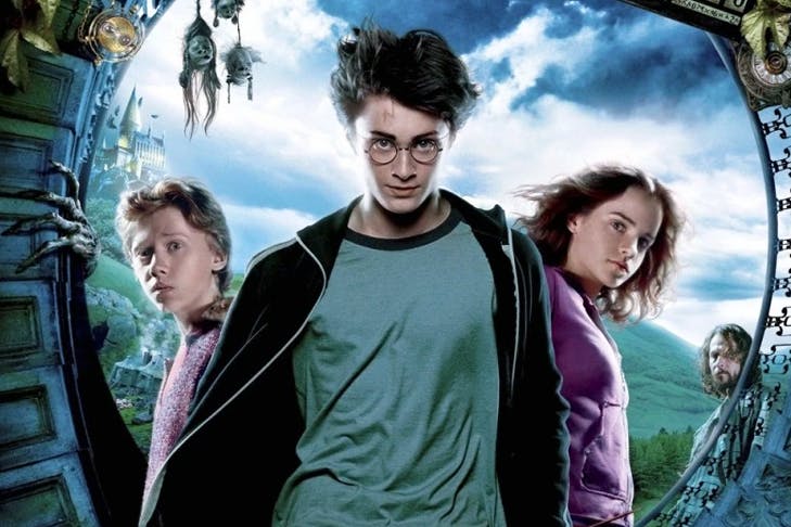 three people standing with looming clouds behind them